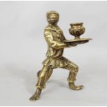 A heavy cast brass candlestick in the form of a monkey in costume supporting a tray and vase, 90cm