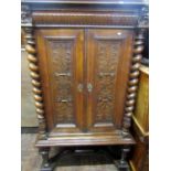 19th Century side cabinet in an Elizabethan manner enclosed by two carved and panelled doors flanked