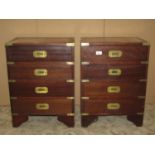 A pair of small hardwood four drawer chests in the military/campaign style with brass flush fittings