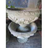 A pair of cast composition stone two sectional garden urns, the circular shallow bowls with raised