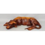 A good carved hardwood figure of a recumbent hound, 64cm long