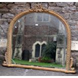 A Victorian style overmantle mirror with bevelled edge plate within a moulded gilt arched frame with