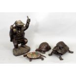 A cast bronze figure of a turtle, in standing pose, bearing sticks, together with three further