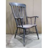 Two similar stained elm and beechwood Windsor lathe back elbow chairs with saddle shaped seats and