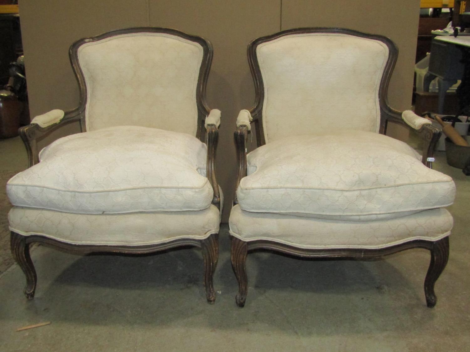 A pair of 19th century fautilles, with cream ground floral patterned upholstered seats and shield