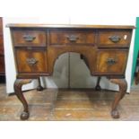 A walnut knee hole writing table in the Georgian manner, five frieze drawers around a central