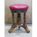 A good quality Edwardian walnut piano/music stool with circular adjustable revolving maroon coloured