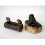 A cold painted bronze figure of a baby chick seated upon a fossilised wood plinth, together with a