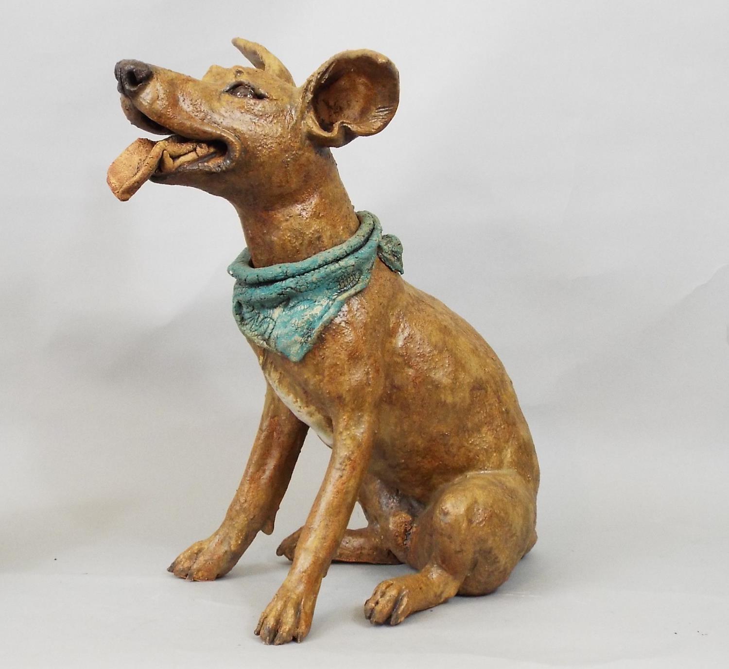 A studio pottery figure of a terrier wearing a scarf, in seated pose, by Joanna Cooke, 32cm high