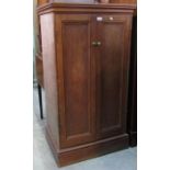 A floorstanding side cupboard enclosed by a pair of slender rectangular panelled doors, the interior
