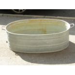 A continental oval galvanised two handled bath with screw cap plug hole, 93 cm long (excluding