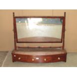 An early 19th century mahogany toilet mirror, the wide rectangular plate raised on ring turned
