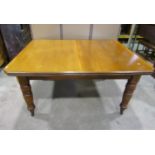 An Edwardian oak and walnut wind-out extending dining table of rectangular form with canted corners,