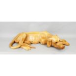A carved hardwood figure of a recumbent hound, 56cm long