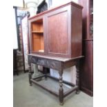 An antique oak side table with rectangular top and carved frieze incorporating a central drawer