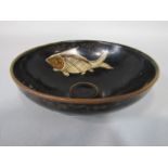 An oriental pottery bowl of circular form with painted fish decoration on a dark brown ground, 15.