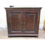 An antique oak side cupboard enclosed by a pair of fielded panelled doors (af) 84cm wide