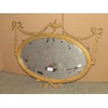 A small Adam style wall mirror of oval form with bevelled edge plate within a reeded gilt frame with