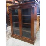 A Victorian mahogany floorstanding bookcase enclosed by a pair of rectangular glazed panelled