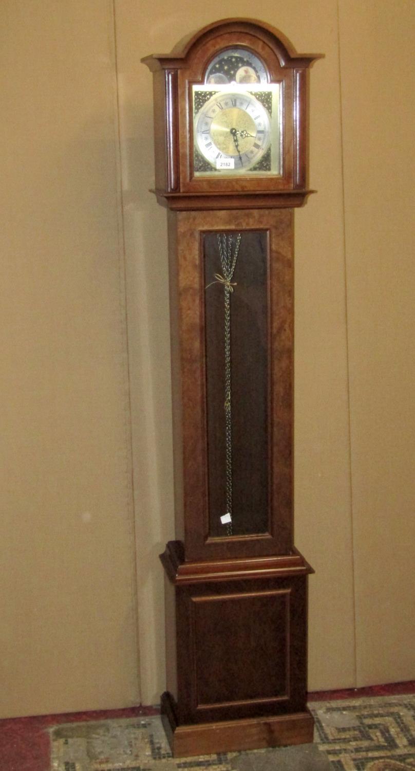 A grandmother clock in the Georgian style with arched hood and dial with lunar phase, glazed trunk