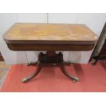 A regency mahogany fold-over top tea table, raised on a square cut column platform and four swept