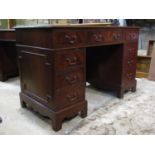 A reproduction mahogany kneehole twin pedestal desk in the Georgian style with inset leather writing