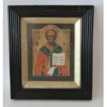 19th century eastern European icon, half length study of a standing saint holding aloft an open