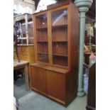 A mid 20th century teak two sectional floorstanding side cabinet, the upper recessed section