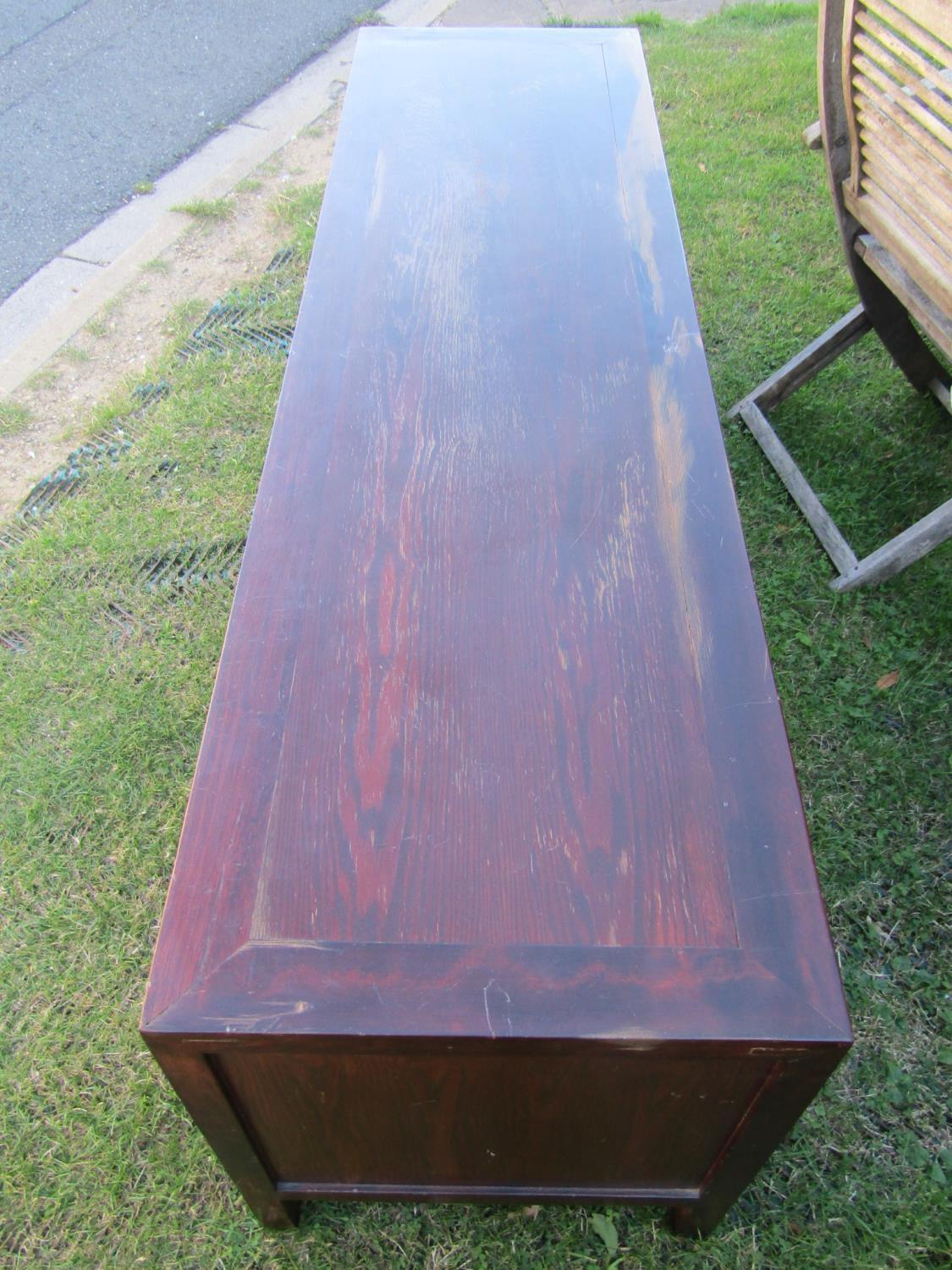 A long and low eastern hardwood side cupboard, partially enclosed by two doors, flanked by four - Image 2 of 2