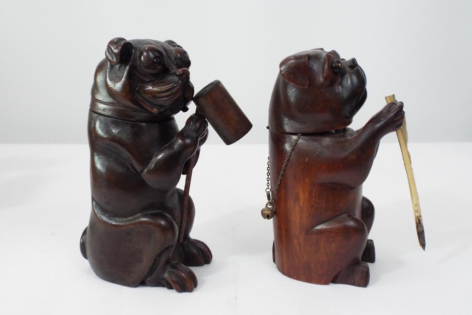 Two carved soft wood models of Bulldogs, both with hinged necks, one supporting a tankard, the other