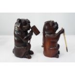 Two carved soft wood models of Bulldogs, both with hinged necks, one supporting a tankard, the other