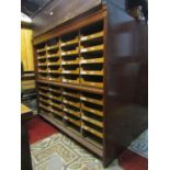 A pair of vintage floorstanding haberdashery cabinets with moulded outline enclosing a segmented