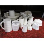 A collection of white glazed kitchen and useful wares including a jelly mould of fluted form, a