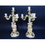 A pair of late 19th century continental three branch candelabra with encrusted floral decoration and
