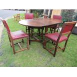 An oak oval drop leaf gateleg dining table raised on turned supports and stretchers together with