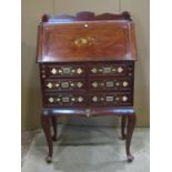 A reproduction hardwood bureau with decorative brass inlay with raised three quarter gallery over