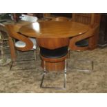A contemporary modernist/retro style walnut veneered dining table of circular form raised on a