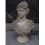 A small weathered buff coloured composition stone female head and shoulder bust 40 cm high