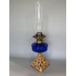 Edwardian gilt cast metal oil lamp with blue glass reservoir, 30cm high