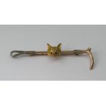 9ct tri-colour stock pin in the form of a riding crop, with applied fox mask with ruby set eyes,