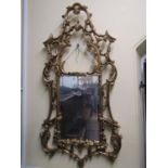 A gilt framed wall mirror in an 18th century classical style enclosing a bevelled edge mirror plate,