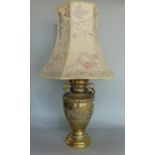 A Chinese polished bronze baluster vase converted to a table lamp, the vase with embossed servant