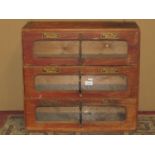 A vintage oak three drawer haberdashery cabinet with glazed panelled fronts, anodised handles and