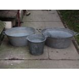 Two similar galvanised oval two handled tin baths together with a further galvanised bucket with
