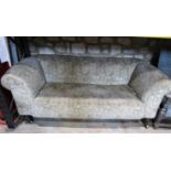 A Victorian Chesterfield sofa with floral patterned upholstery on a beige ground and rolled drop