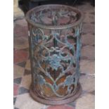 A cast iron umbrella stand of cylindrical form with pierced scrolling foliate detail and removable