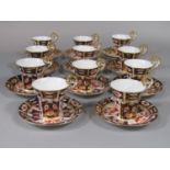 A collection of eleven Royal Crown Derby coffee cups with scrolling handles and imari style