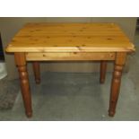 A modern pine kitchen table of rectangular form with moulded outline and raised on four turned,