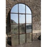 A reclaimed 19th century iron framed arched window with central bi-opening and enclosing segmented