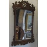 A Chippendale style wall mirror, walnut veneered with fret carved outline and hoho bird detail, 74